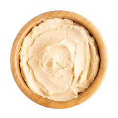 Classic chickpea hummus in wooden bowl isolated on white.