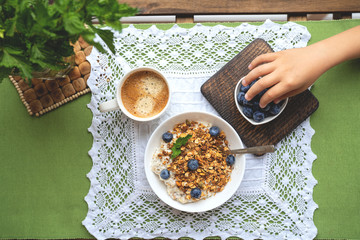Breakfast with oatmeal, granola and blueberry on wooden background