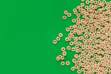 Top view of cereal rings on green background