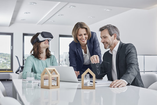 Business people having a meeting in office with VR glasses, laptop and architectural models