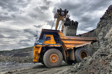Large quarry dump truck. Loading the rock in the dumper. Loading coal into body work truck
