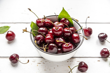 Bowl of cherries on white wood