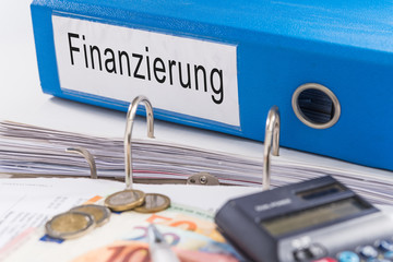 Aktenordner mit Finanzierung, Geldscheine, Münzen und Taschenrechner