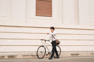 Fototapeta premium Outdoor portrait of handsome young man with fixed gear bicycle in the street.