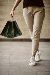Close up of woman`s legs walking on street.