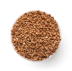 Dry buckwheat in ceramic bowl isolated on white.