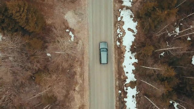Car drives through forest from above