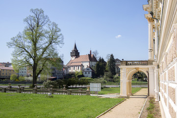 Fototapeta na wymiar Church of St. Wenceslas in town Svetla nad Sazavou, clock tower, greenery and blue sky