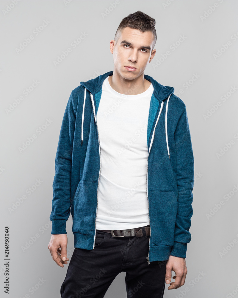 Wall mural Studio portrait of confident young man in hoodie