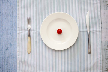 Heart shape on a round white plate. The table is served with a fork and knife.