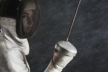Female fencer portrait at black studio background