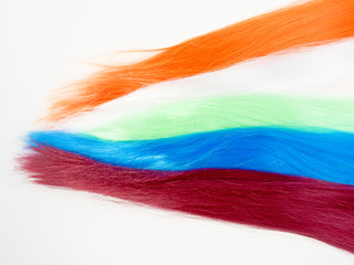 Palette samples of dyed hair. Strands of artificial hair, wigs on a light background