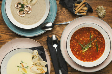 Three different soups on wooden table