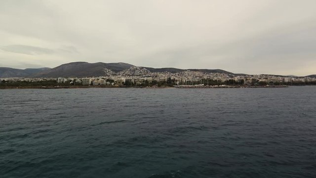 Flying over the sea on a cloudy day. Small island on the horizon.