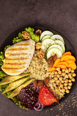 Bowl of Buddha, The concept of a healthy diet: grilled chicken, avocado, chickpeas, kinua, carrots, tomatoes, nuts. Balanced food. Top view. Copy space.Toned.