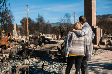 Man and his wife owners, checking burned and ruined of their house and yard after fire, consequences of fire disaster accident. Ruins after fire disaster. - obrazy, fototapety, plakaty