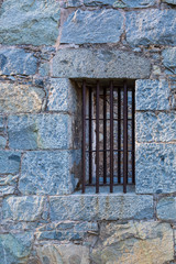 Old jail house wall and window with iron bars