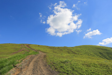 mountain road across green hill