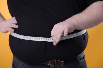 The big man makes measurements with the tape of his fat stomach.