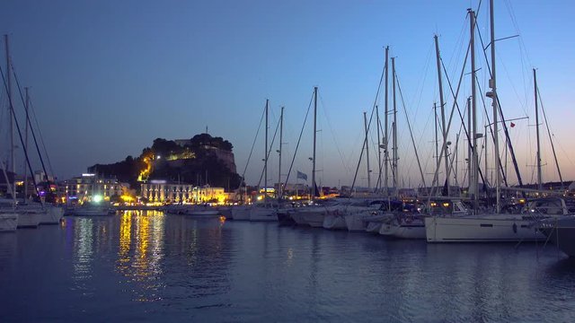 Sunset time in recreational and tourist marina located in the town of Denia, Alicante, on the Mediterranean coast.The Denia Castle on the background, with its more than two thousand years of history.
