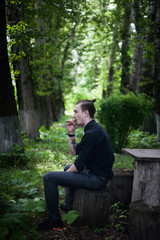 Young handsome stylish man smoking cigar