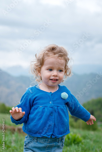 Close Up Cute Little Baby Girl With Curly Blonde Hair Walking On