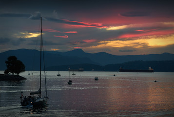 Evening Cruise, English Bay. A sailboat heads out into English Bay at sunset. Vancouver, British...
