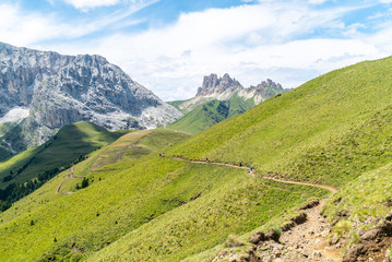 Italian Dolomites Landscape. Light after rain in Dolomites. Rocky peaks in the background surrounded by rain clouds. Mountain valley with layers of forest and mountains. Aerial view path trail hikeing