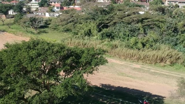 Aerial clip of the countryside, with a dir road in the frame.