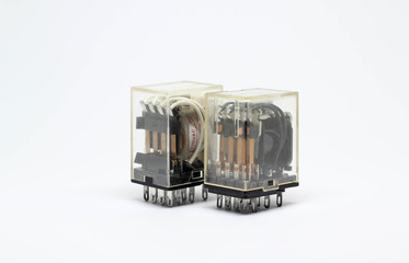 Two electrical auxiliary relay in transparent plastic cases on white background.