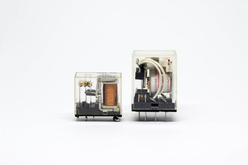 Two electrical auxiliary relay in transparent plastic cases on white background.