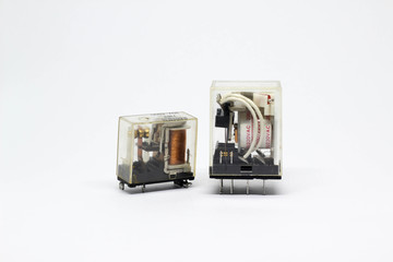 Two electrical auxiliary relay in transparent plastic cases on white background.