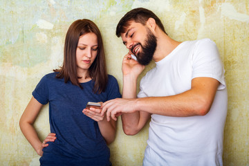 Young couple in casual clothes uses their smartphones