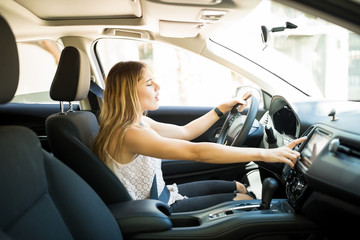 Female driver switching radio stations