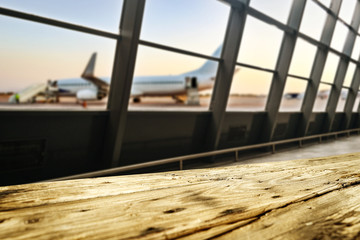 Wooden desk of free space and airport background with big window 