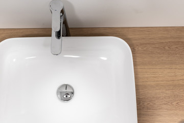 White modern sink on a domestic room on a wooden background
