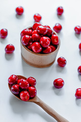 Red ripe cherries with wooden spoon on white background. Flat lay. Food concept.