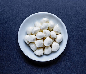 mozzarella balls in plate on black background, top view. Flat lay. Food concept.