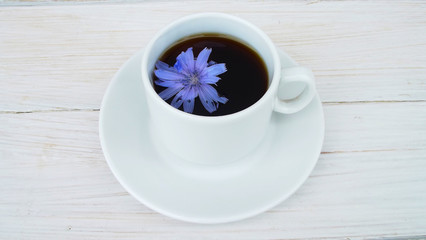 Delicious and healthy beverage from chicory, on wooden background.