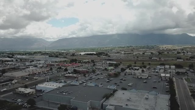 Small community with a busy highway and beautiful mountains and clouds in the background