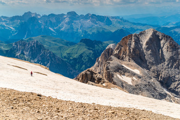 Ascent to Marmolada, Dolomites, Italy. The Marmolada Glacier. Tourist climbing on Marmolada mountain in dolomites. Ice axe in the snow. Ascending Glacier. View from the top of the mountain summit