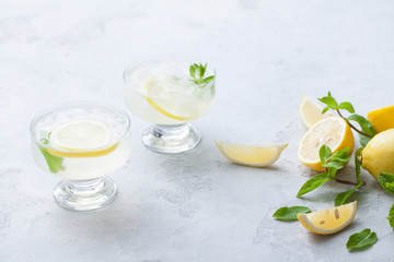 Citrus linfused emonade water with lemon sliced , healthy and detox water drink in summer on concrete table.
