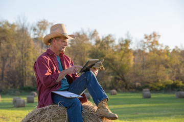 Rancher Making Notes and Using Digtial Tablet