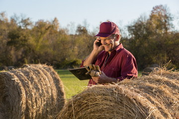 Farmer using tablet and talking on mobile phone