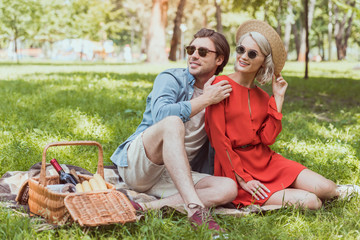 couple sitting and hugging on blanket in park