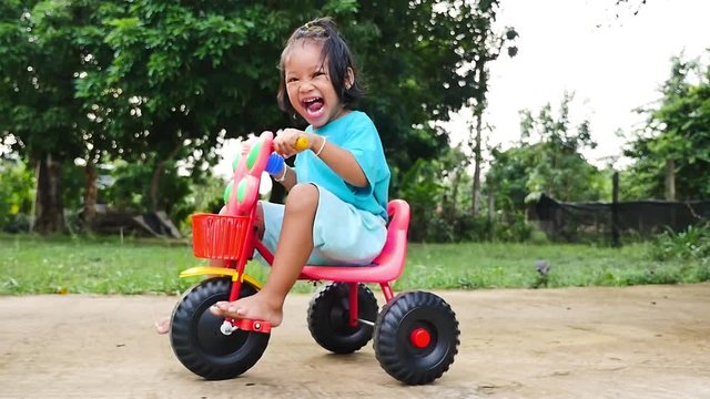 Little girl drive tricycle have fun