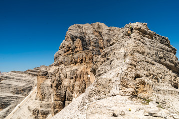 Climbers silhouette standing on a cliff in Dolomites. Tofana di Mezzo, Punta Anna, Italy. Man Celebrate success on top of the mountain Hiker standing on rocky ridge and enjoying  the view in Dolomites