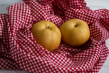 Two chinese pears were wrap by table cloth,on timber board