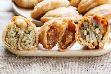 Curry puff  pastry with soybean,pineapple,chicken stuffed on wooden plate.