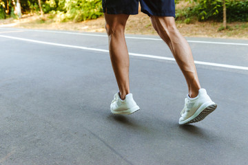 Fototapeta na wymiar Back view of muscular sportsman legs jogging